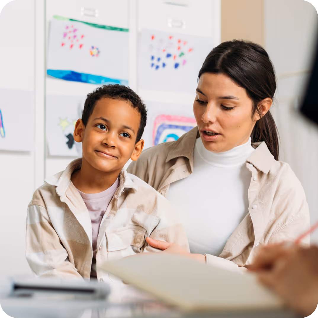 A clinician talking through a book with a smiling boy