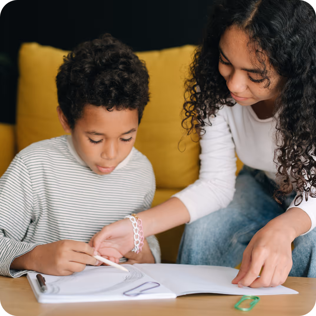 A therapist guiding a boy through a handwriting exercise