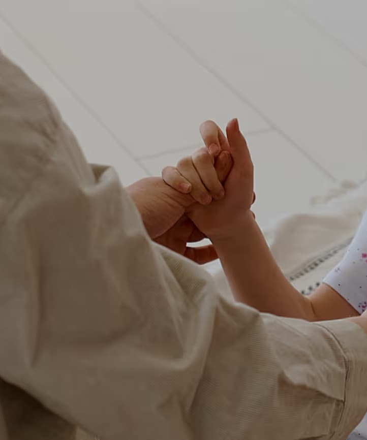 A therapist supporting a young child's hands during practice